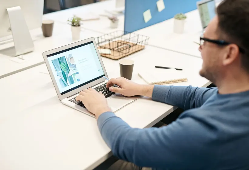 Symbolbild: Eine Person arbeitet im Büro am Laptop.