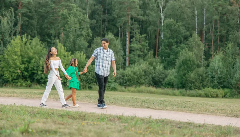 Symbolbild: Eine Familie geht Hand in Hand durch den Wald.